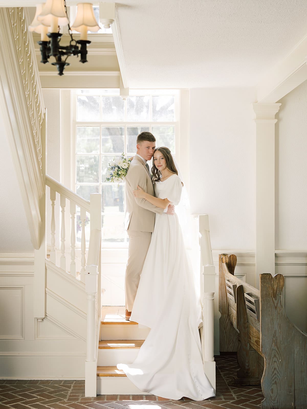 Bride and groom portrait on staircase inside Whitefield Chapel at Bethesda Academy wedding venue near Savannah Georgia
